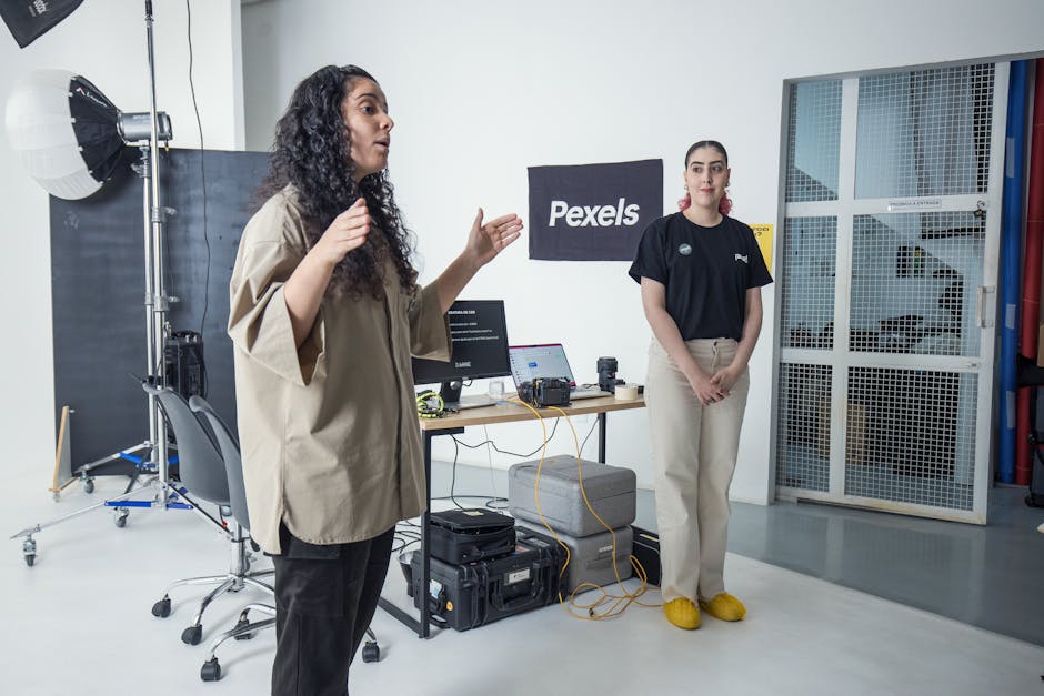 Two women in a photography studio with equipment and a Pexels banner.