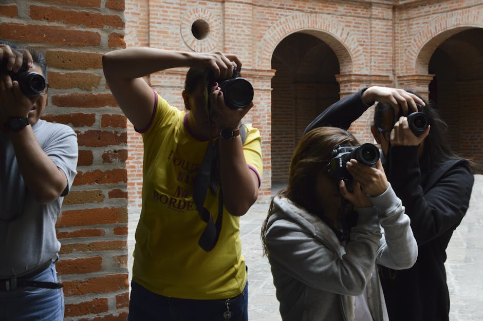 Photographers taking pictures inside a brick building with DSLR cameras.