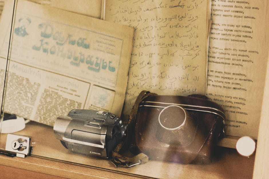 Retro camera and historical scripts under glass, evoking nostalgia.